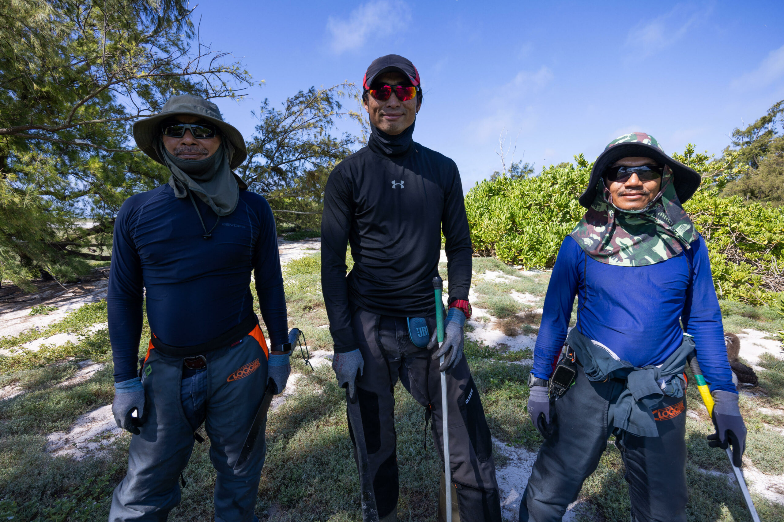 Three men pose before helping clear out Verbesina