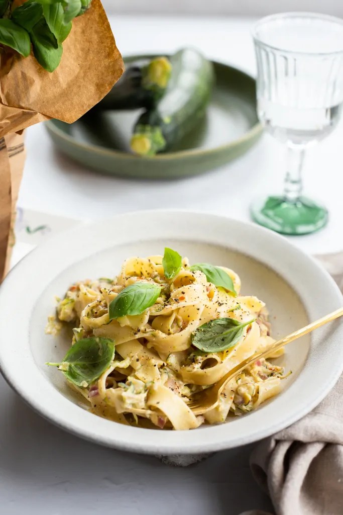 Creamy Zucchini Pasta served in a bowl and topped with fresh basil, and black pepper.