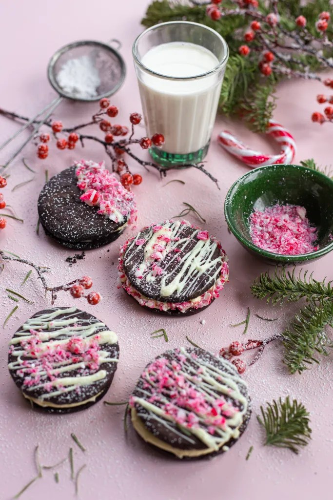 Chocolate Peppermint Sandwich Cookies drizzled with white chocolate and topped with crushed candy canes, perfect for holiday baking.