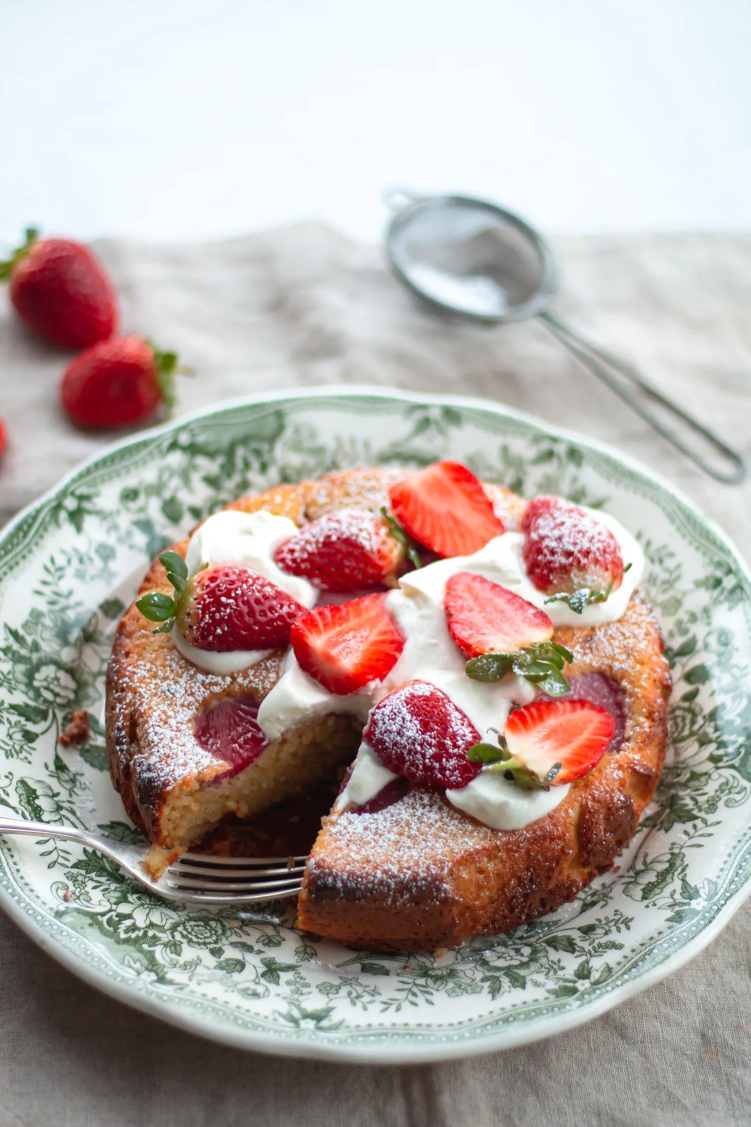 a strawberry summer cake garnished with whipped cream and fresh strawberries