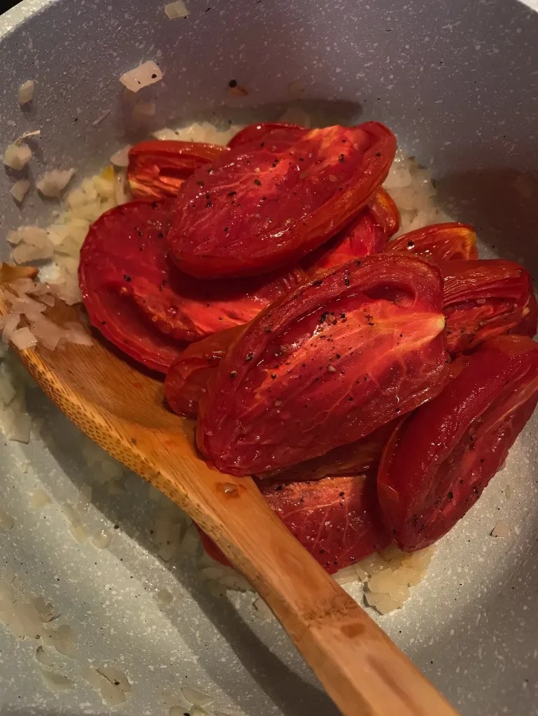 roasted tomatoes sauteing in a pan