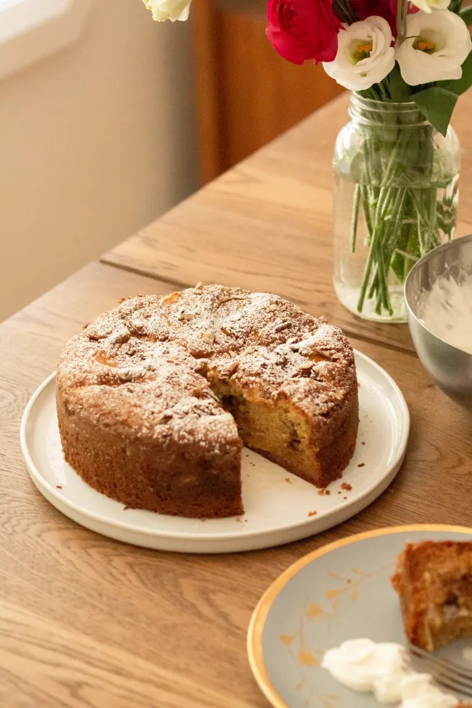 fresh peach cake on a serving platter dusted with icing sugar