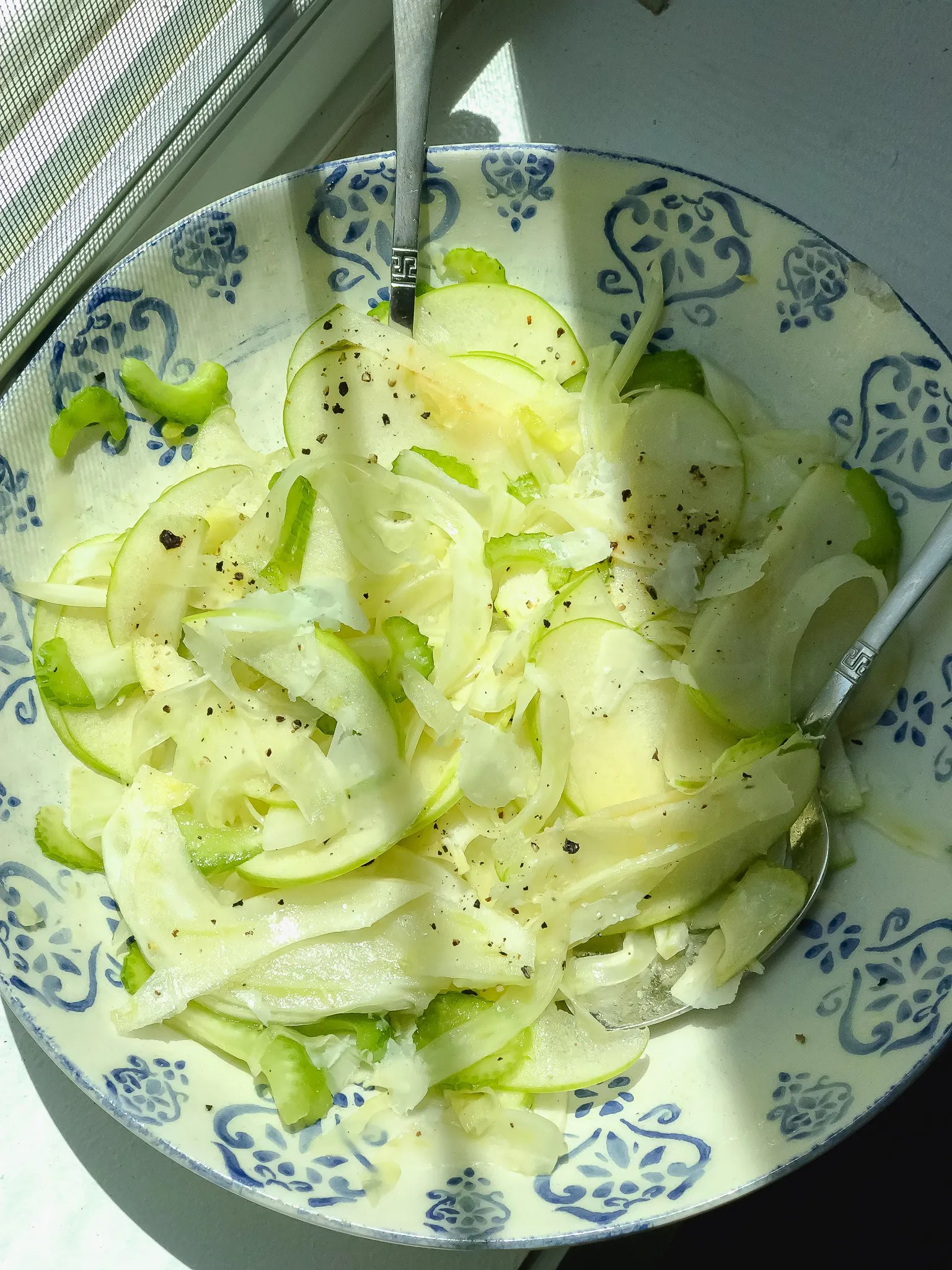 overhead shot of apple and fennel salad in a ceramic bowl