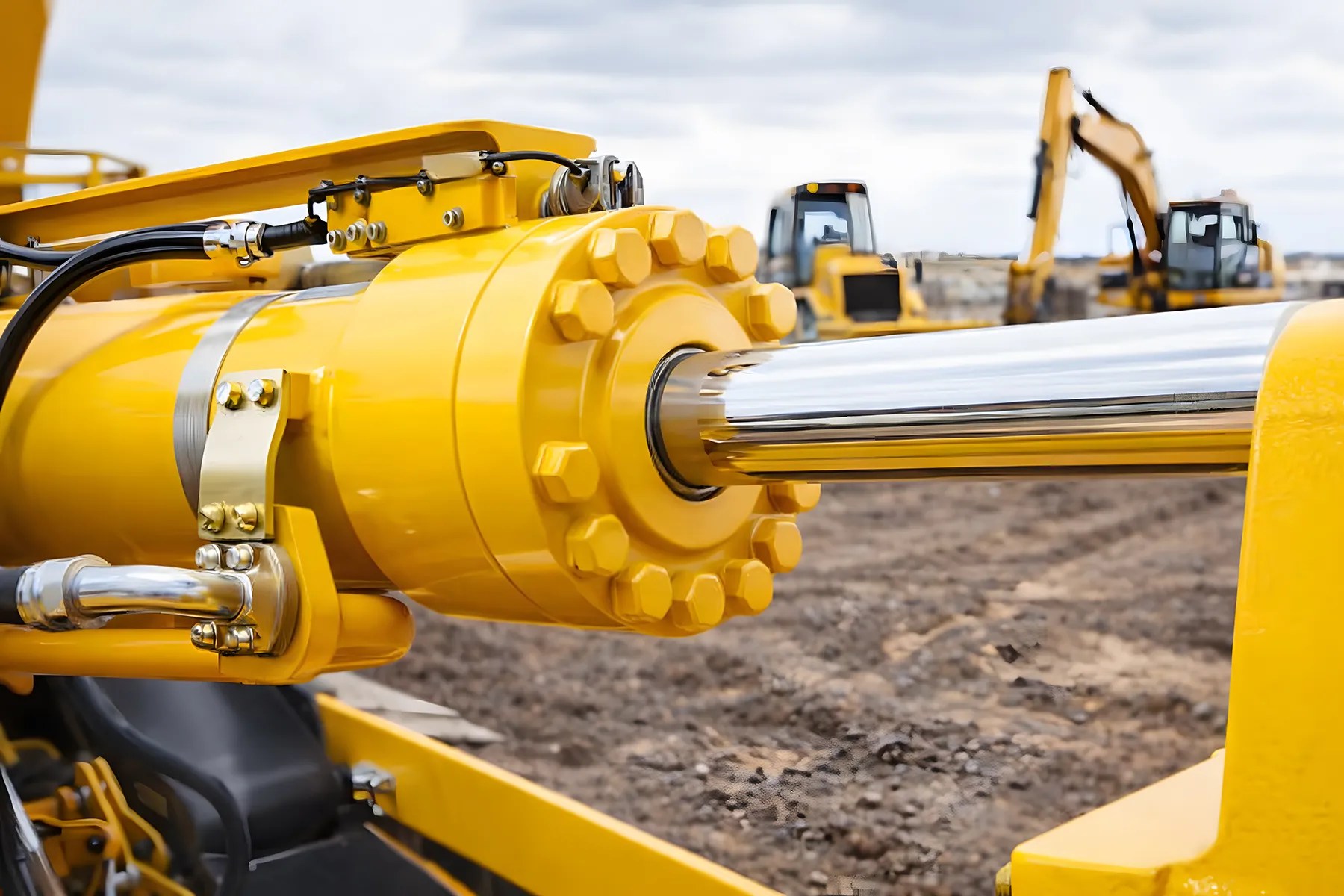Yellow hydraulic cylinder on heavy construction equipment at a jobsite