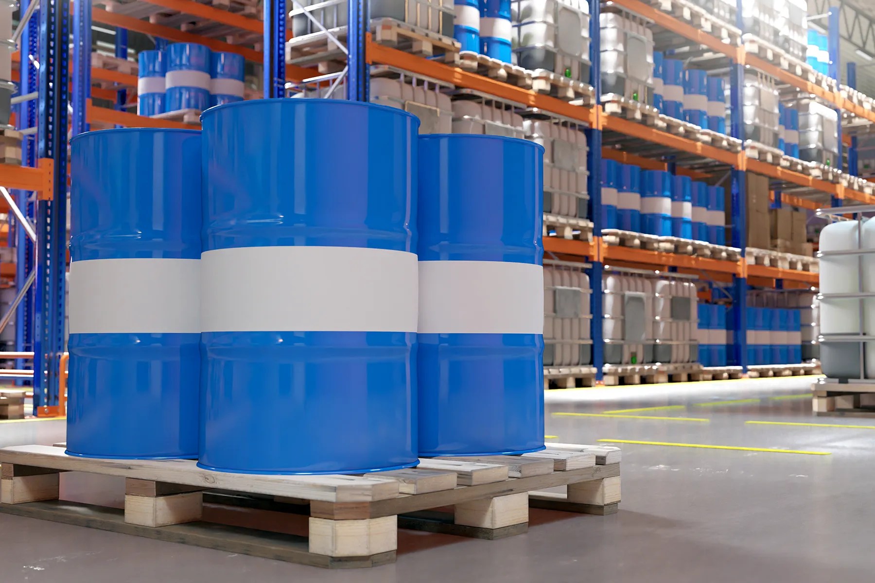 Blue lubricant drums and bulk containers stored in a commercial warehouse