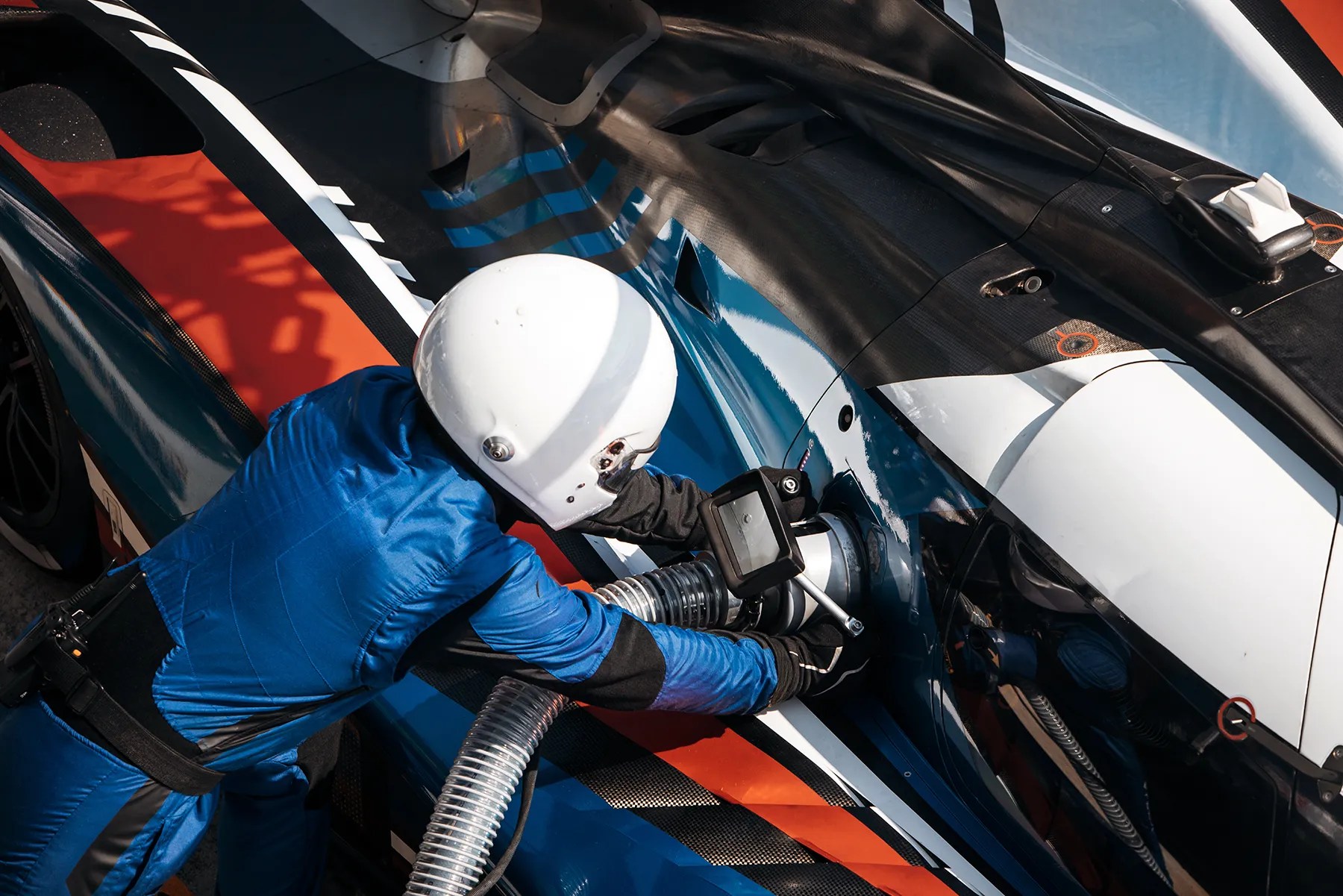 Crew member refueling a race car with high-performance racing fuel
