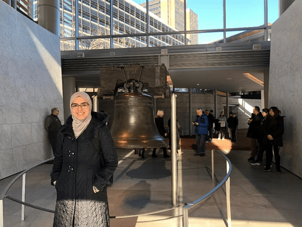Woman in front of the liberty bell.