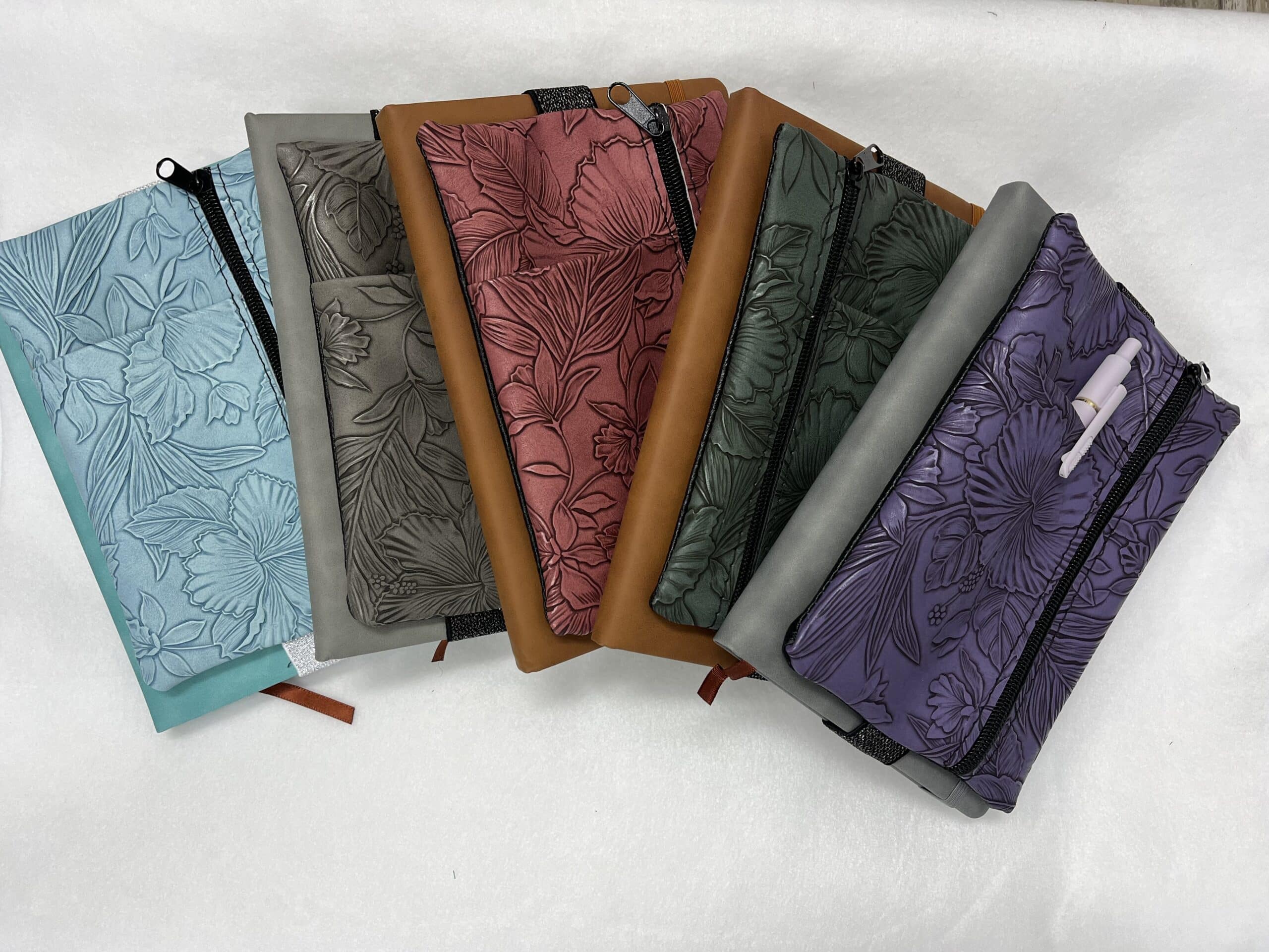 four journal pouches, blue, gray tan and purple