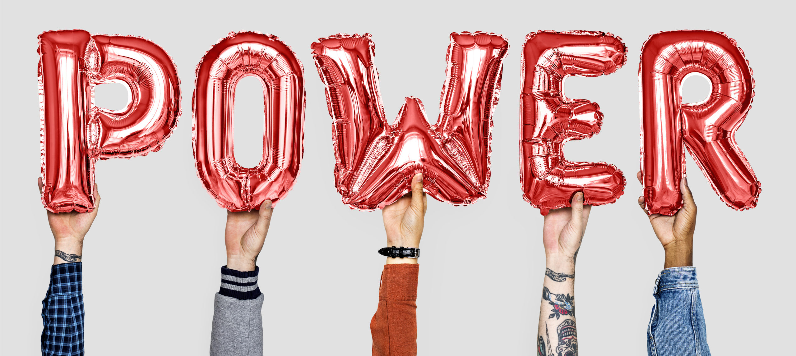 Hands hands holding balloons reading "POWER"