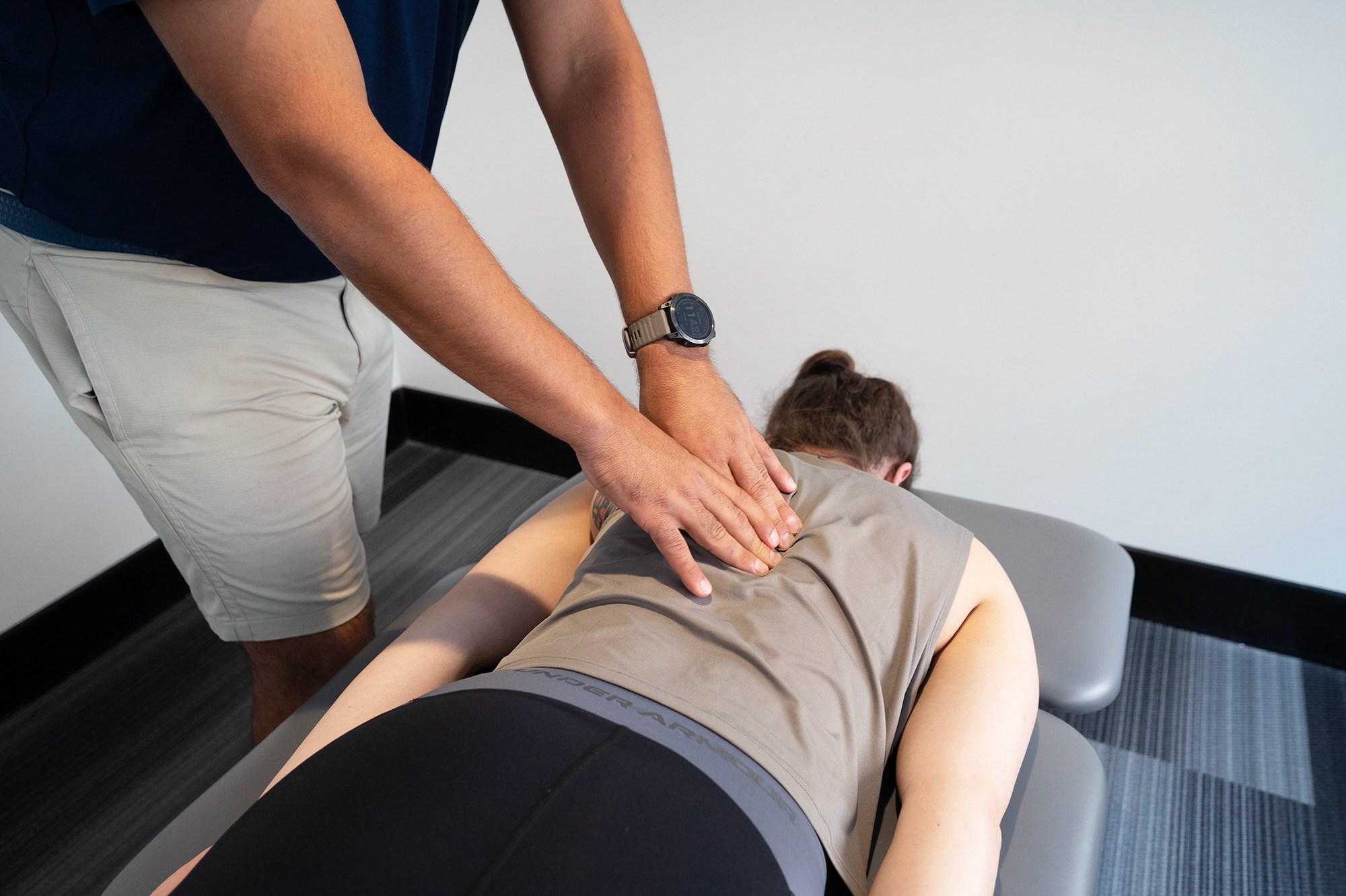 Physical therapist evaluating a patient's back pain