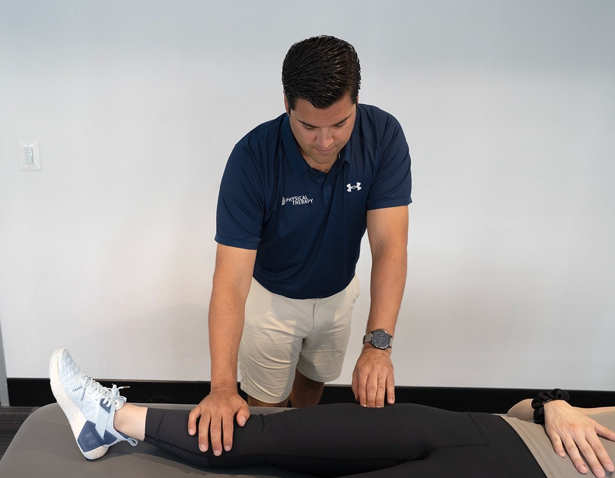 Physical therapist assessing a patient's knee
