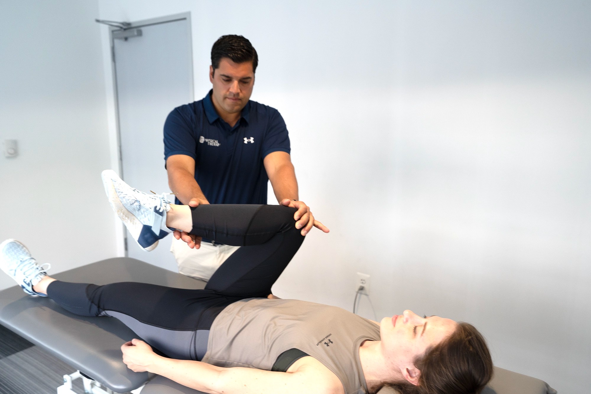 Physical therapist assessing a patient's knee