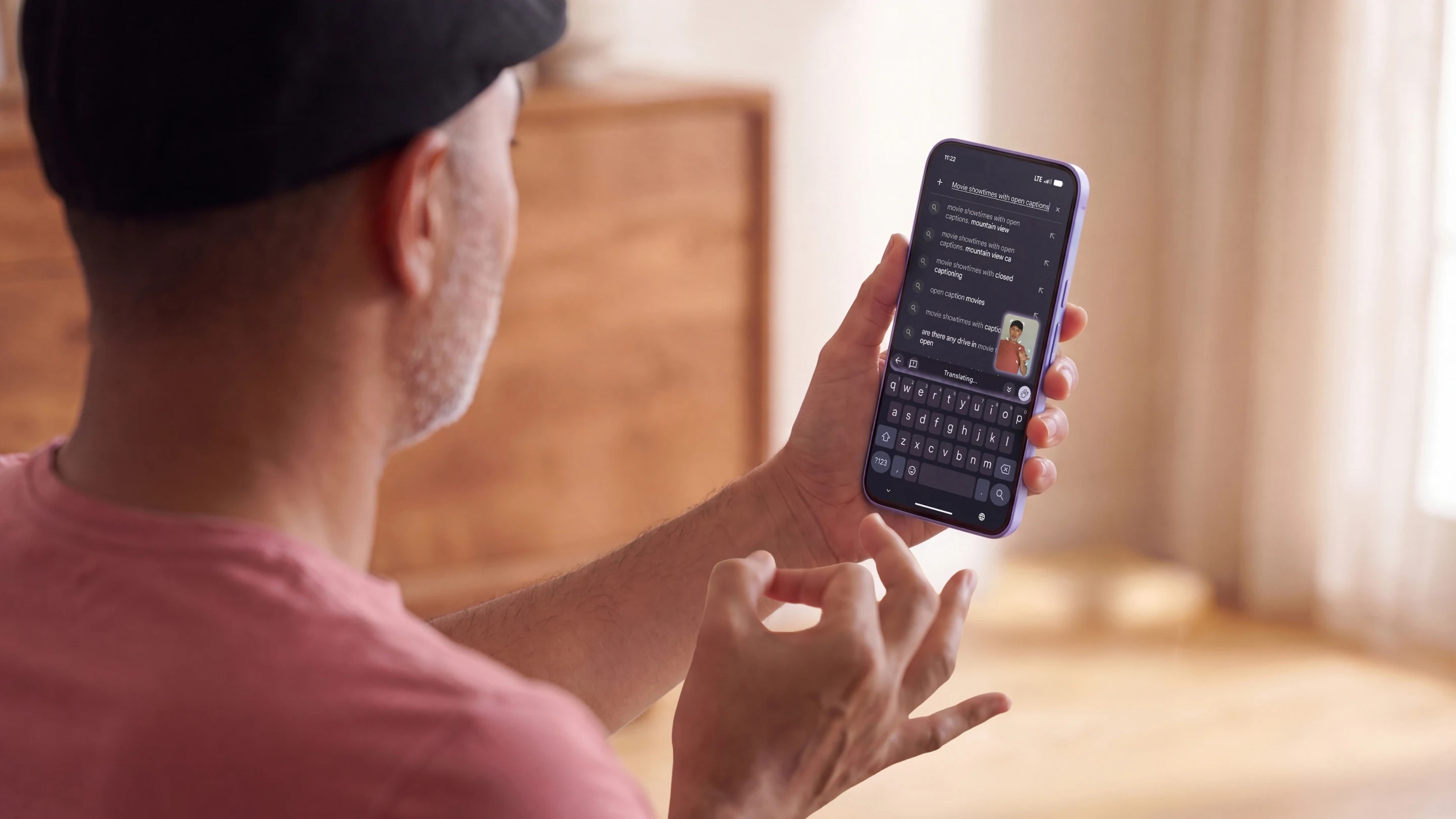 Person signing while holding a smartphone showing Gboard sign-to-text dictation on the screen.
