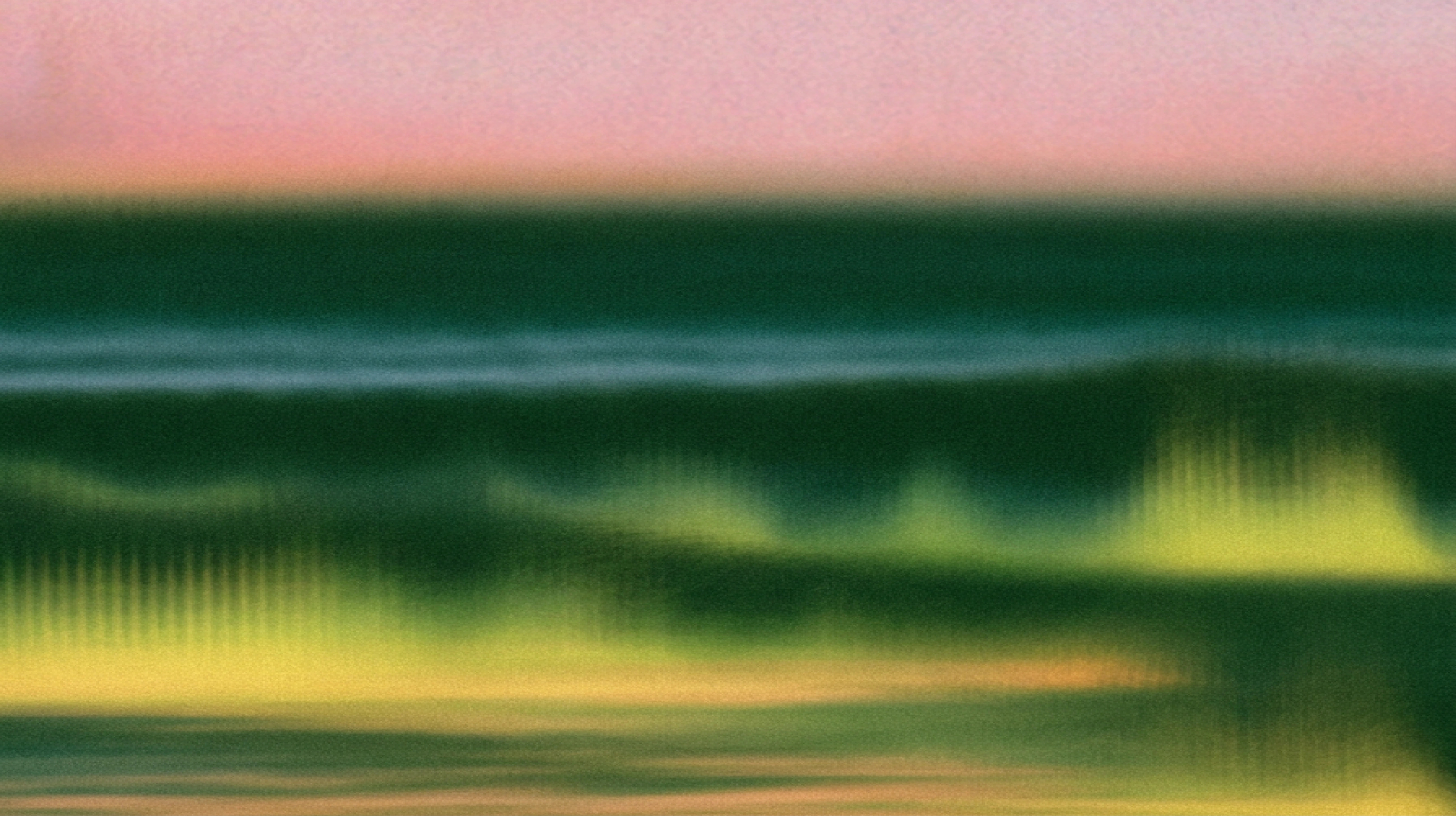 Abstract blurred landscape-like image with dark green horizontal bands, soft yellow-green glowing shapes, and a pale pink sky fading into the background.