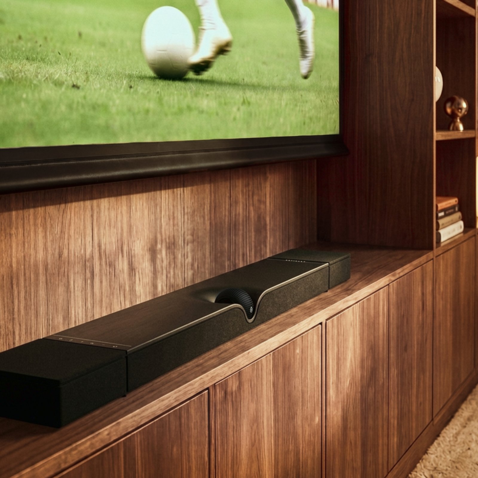 Devialet Dione Soundbar 擺喺木製電視櫃上、電視播緊球賽嘅實景