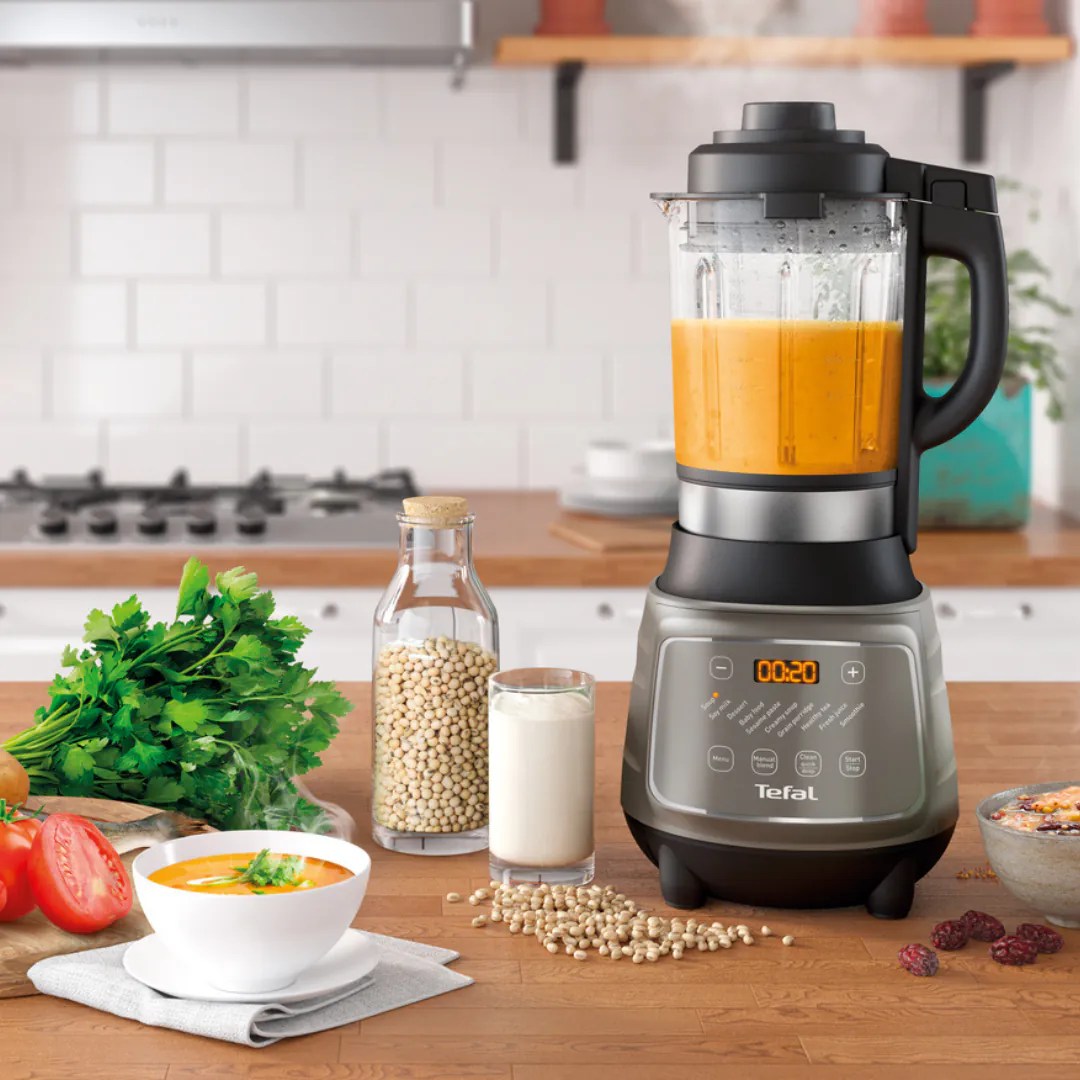 Tefal DynamiX Cook 攪拌機煮好嘅南瓜濃湯，旁邊放住香草同蔬菜