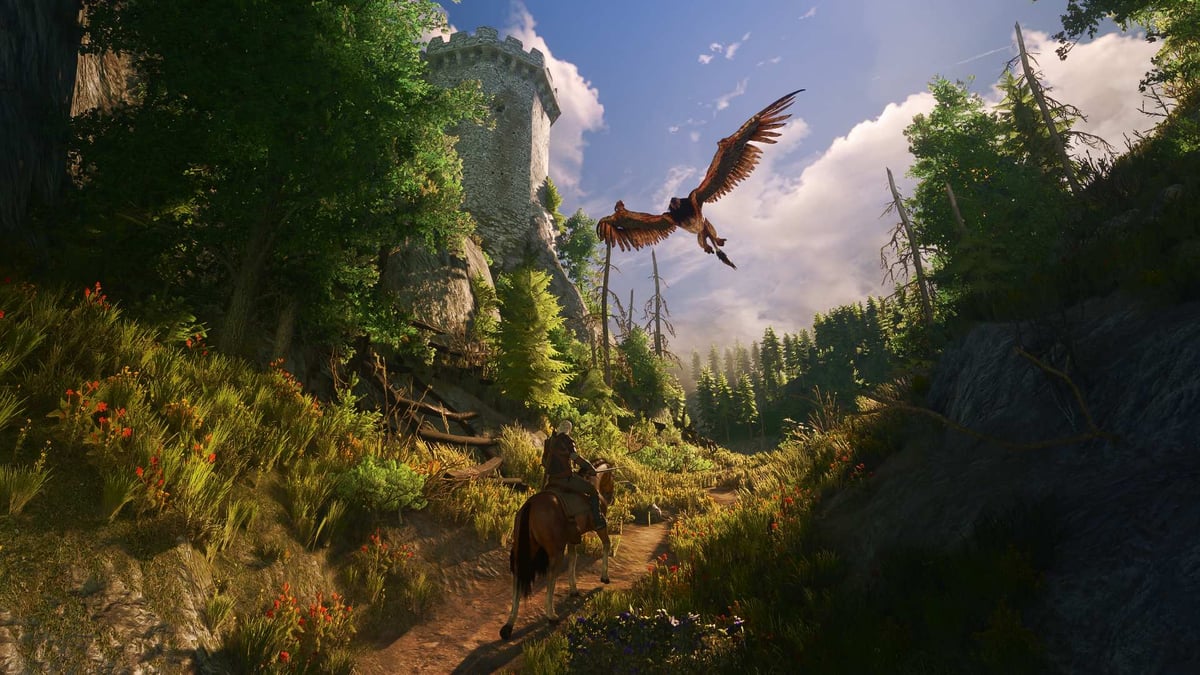 Geralt rides Roach along a forest path below a ruined stone tower as a griffin swoops overhead in The Witcher 3 Remastered