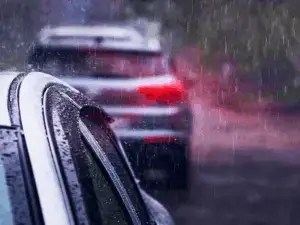 Cars driving in heavy rain, highlighting the importance of a pre monsoon check