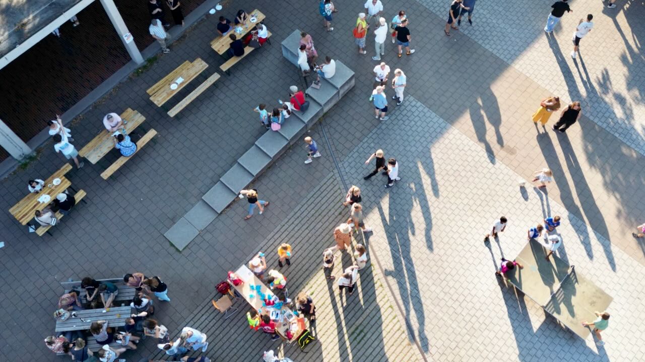 Personen mit unterschiedlichen Aktivitäten auf dem Schulhof 