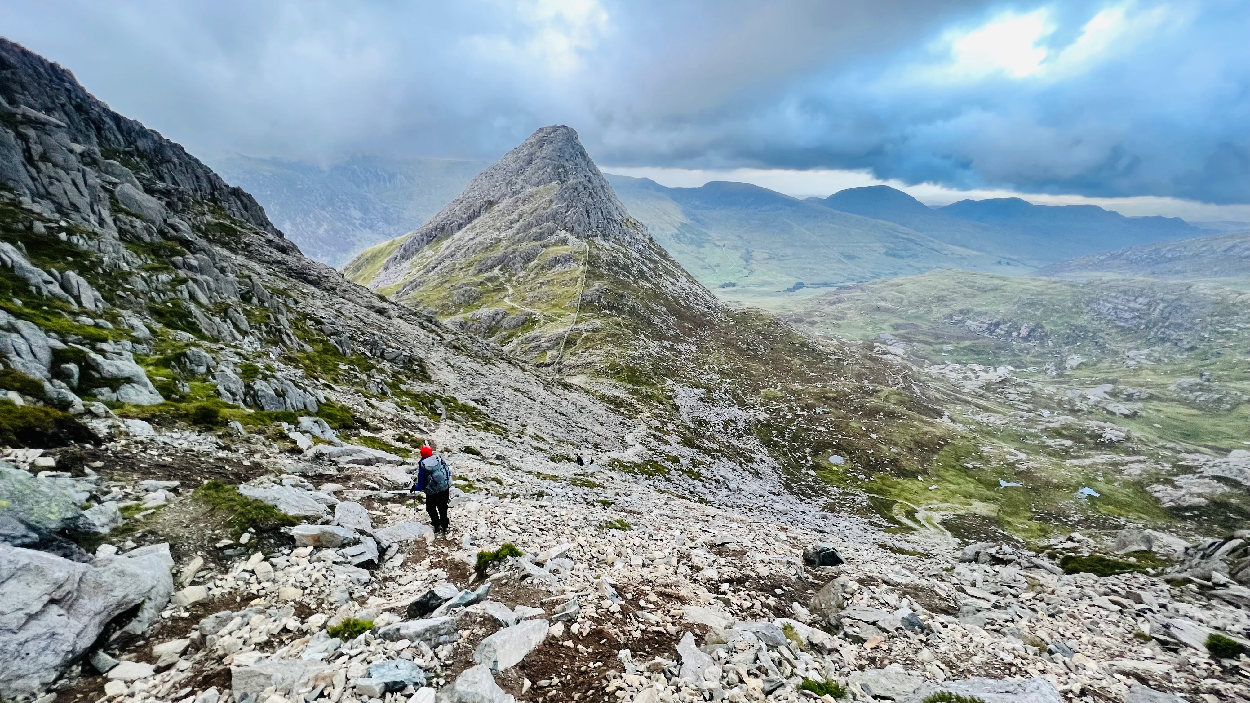 Hiker walking across a rocky mountain landscape in the Lake District
