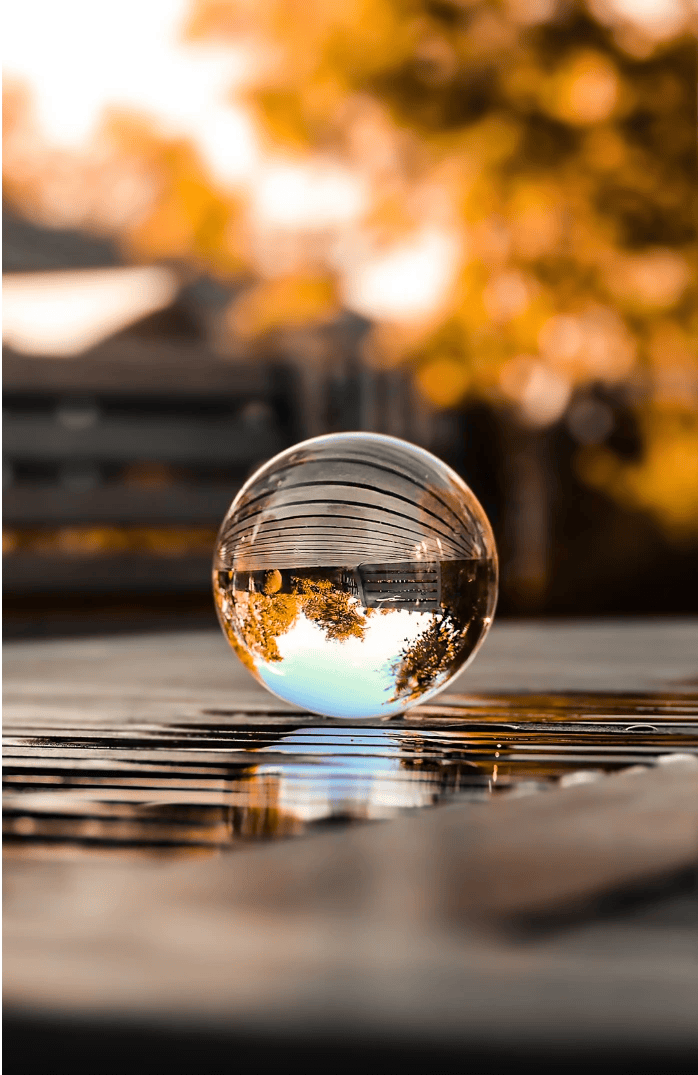Glass orb on Seattle deck reflecting the natural landscape