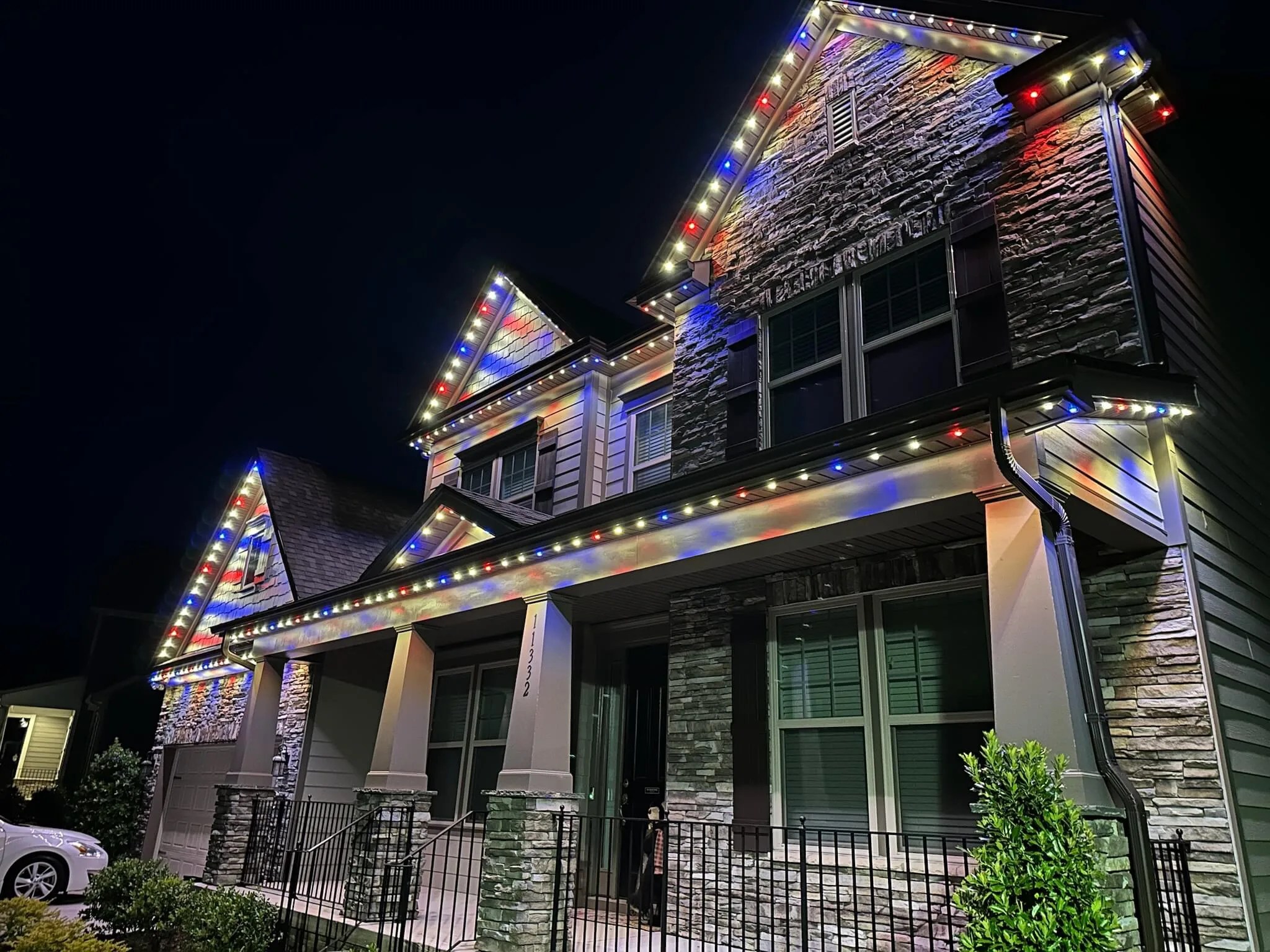 A beautifully decorated house illuminated with colorful lights at night