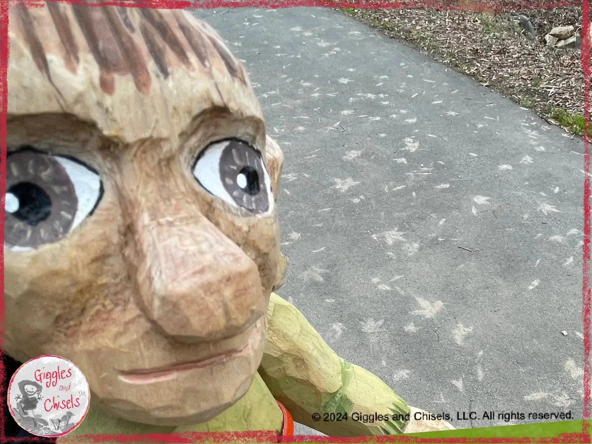 A picture of Pierre Qui Roule, a wooden puppet, in front of a pattern on the ground, made out of leave prints