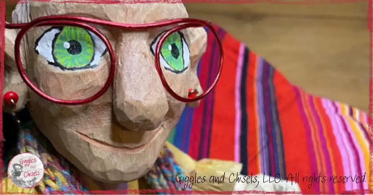 A picture of Mme Rigolotte, a wooden puppet, holding a colorful piece of fabric