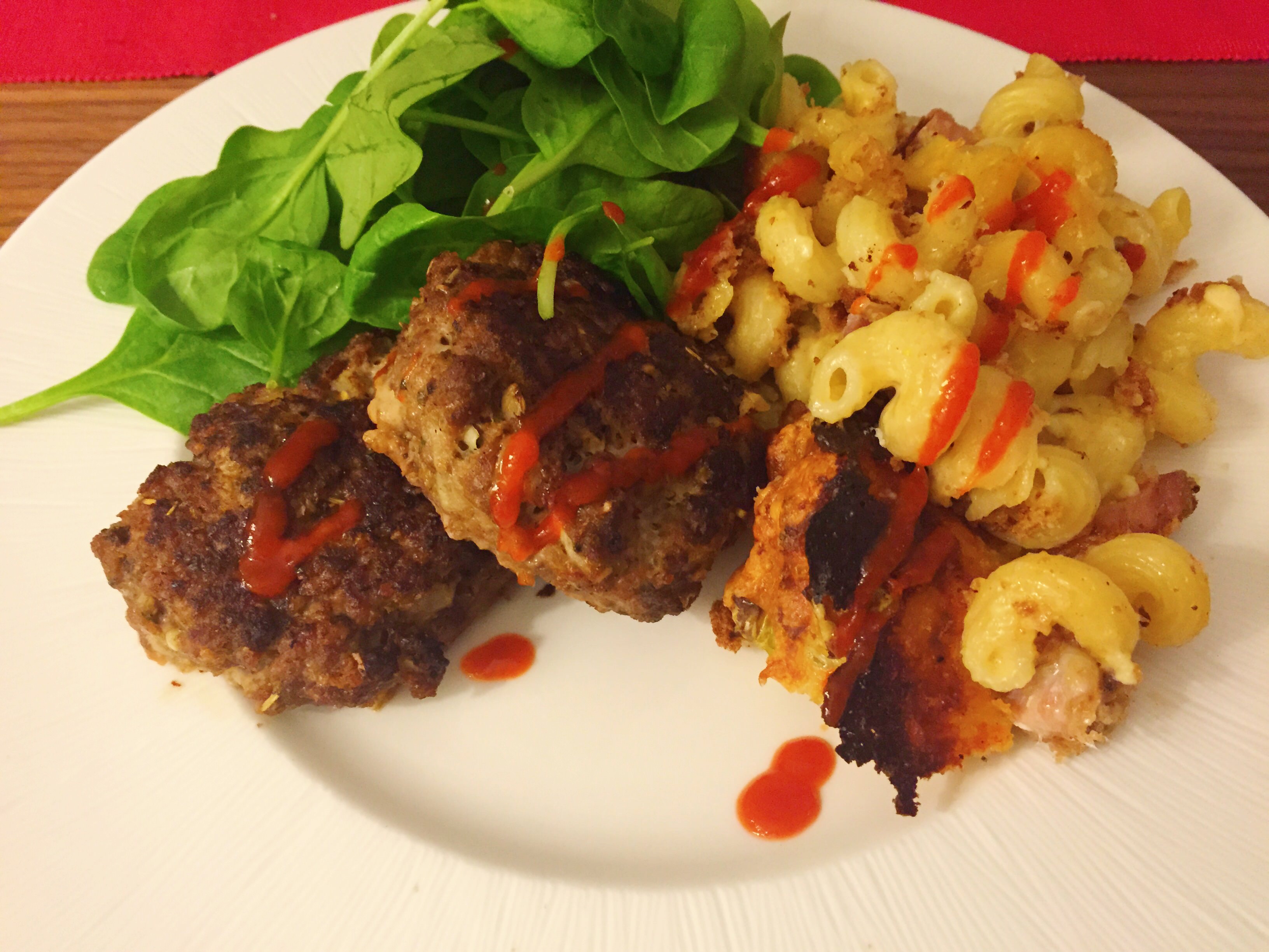 Shot showing the finished dish, served with mac and cheese and salad.