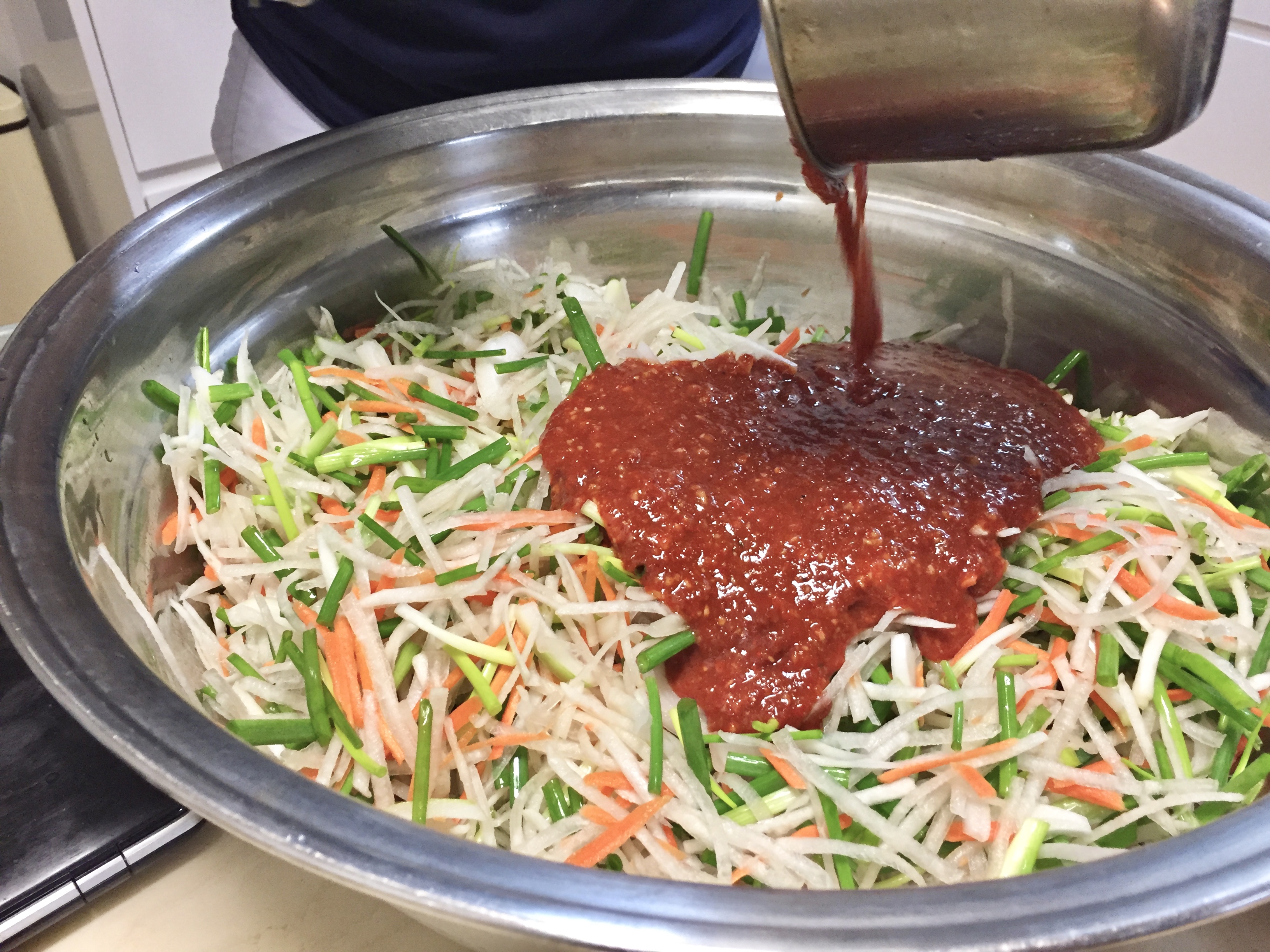 7. Add kimchi sauce to stuffing mix (primarily shredded onion, scallion, buchu, carrot, radish)