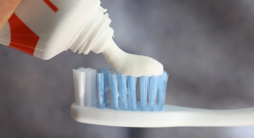 Squeezing toothpaste on toothbrush