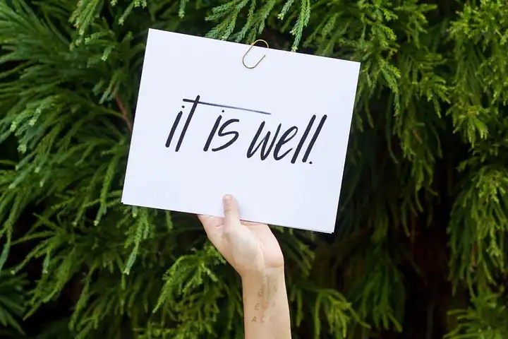 Someone holds up a sheet of paper that states, it is well.