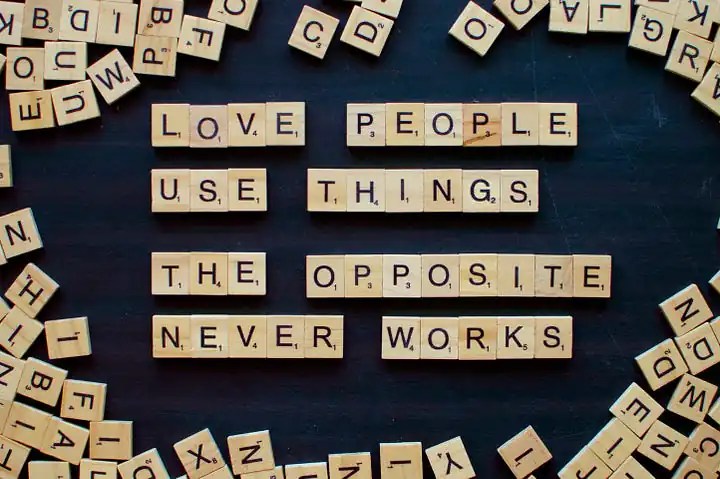 Words made on a scrabble board reads: love people use things the opposite never works.