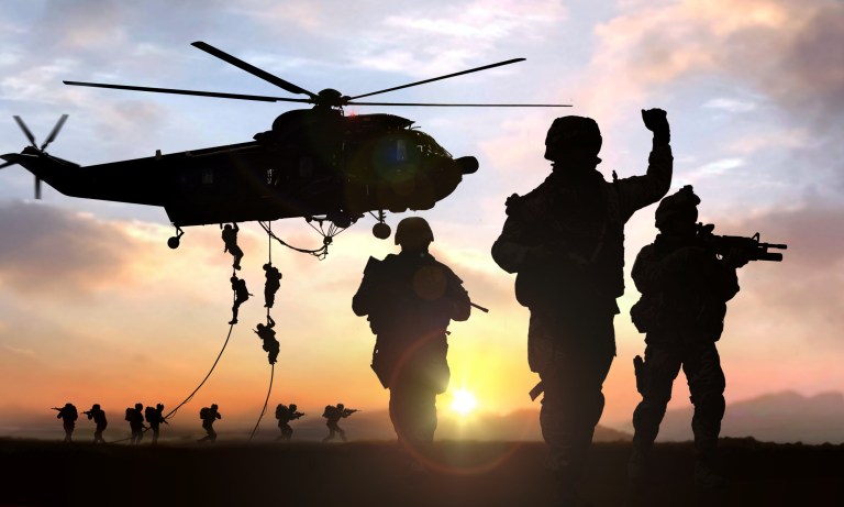 Soldiers dropping out of helicopter on ropes