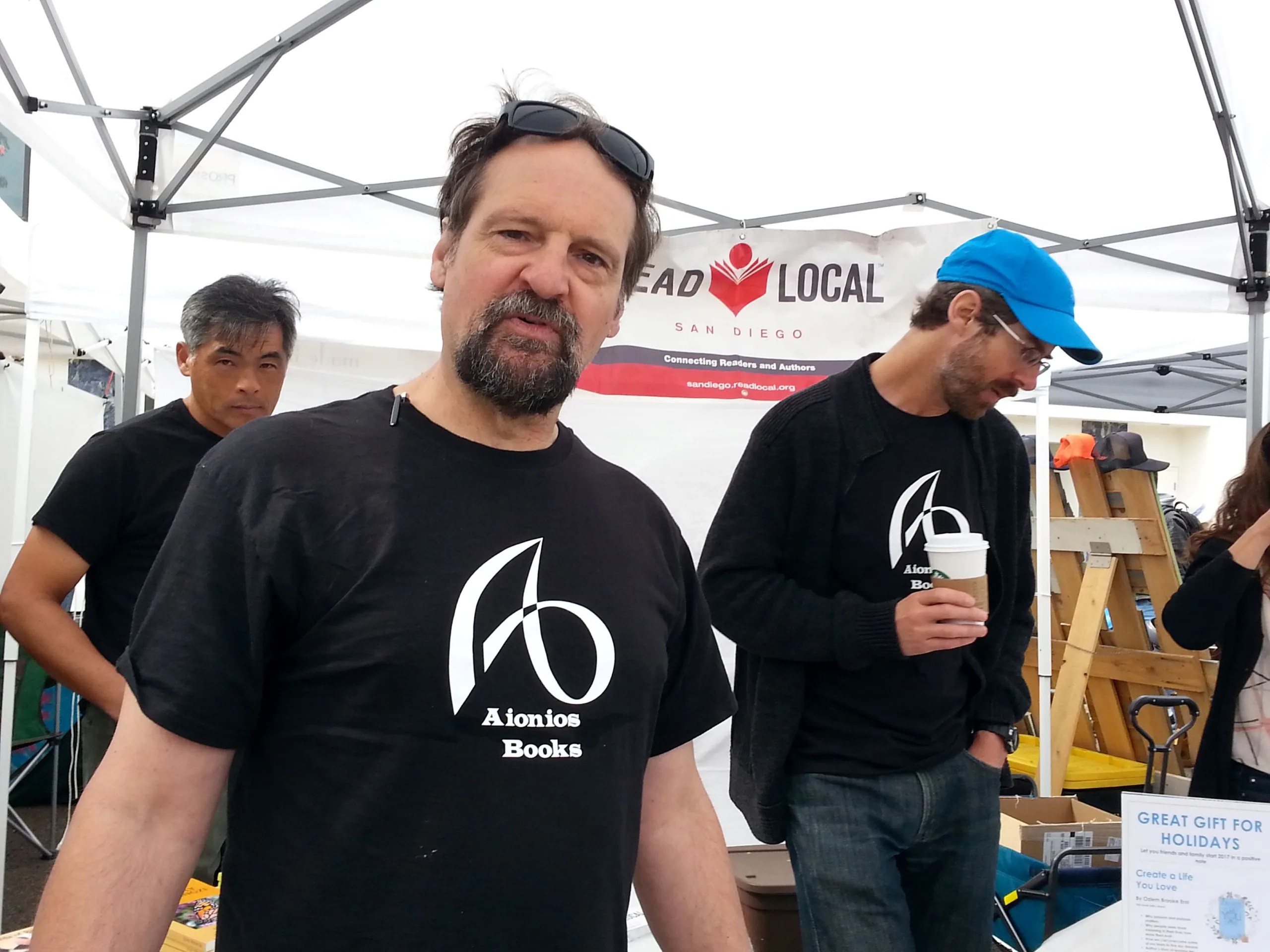 guy with a dark beard and moustache wearing a black graphic tee