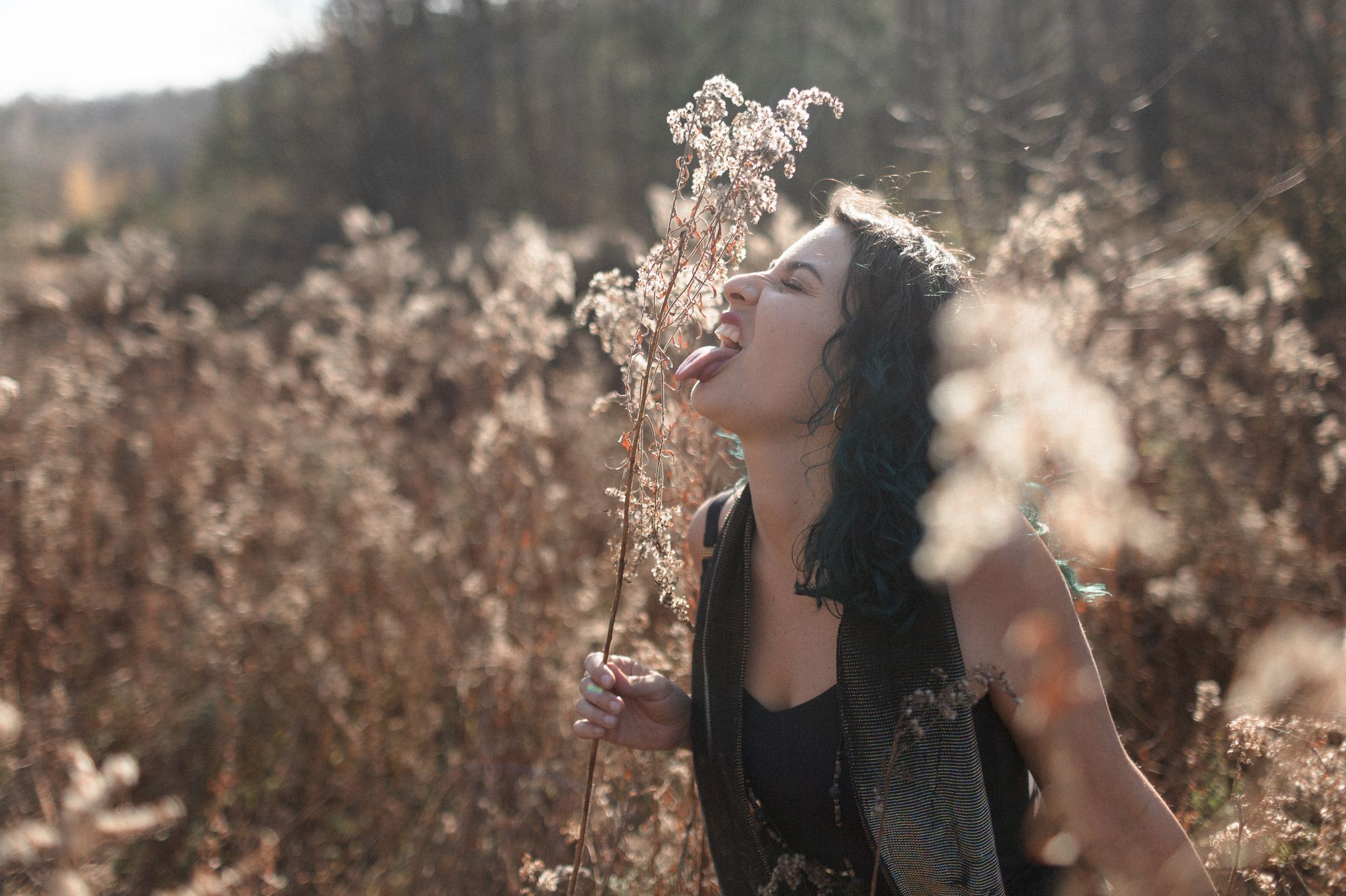 girl in a field of fluffy daffodils with her tongue out