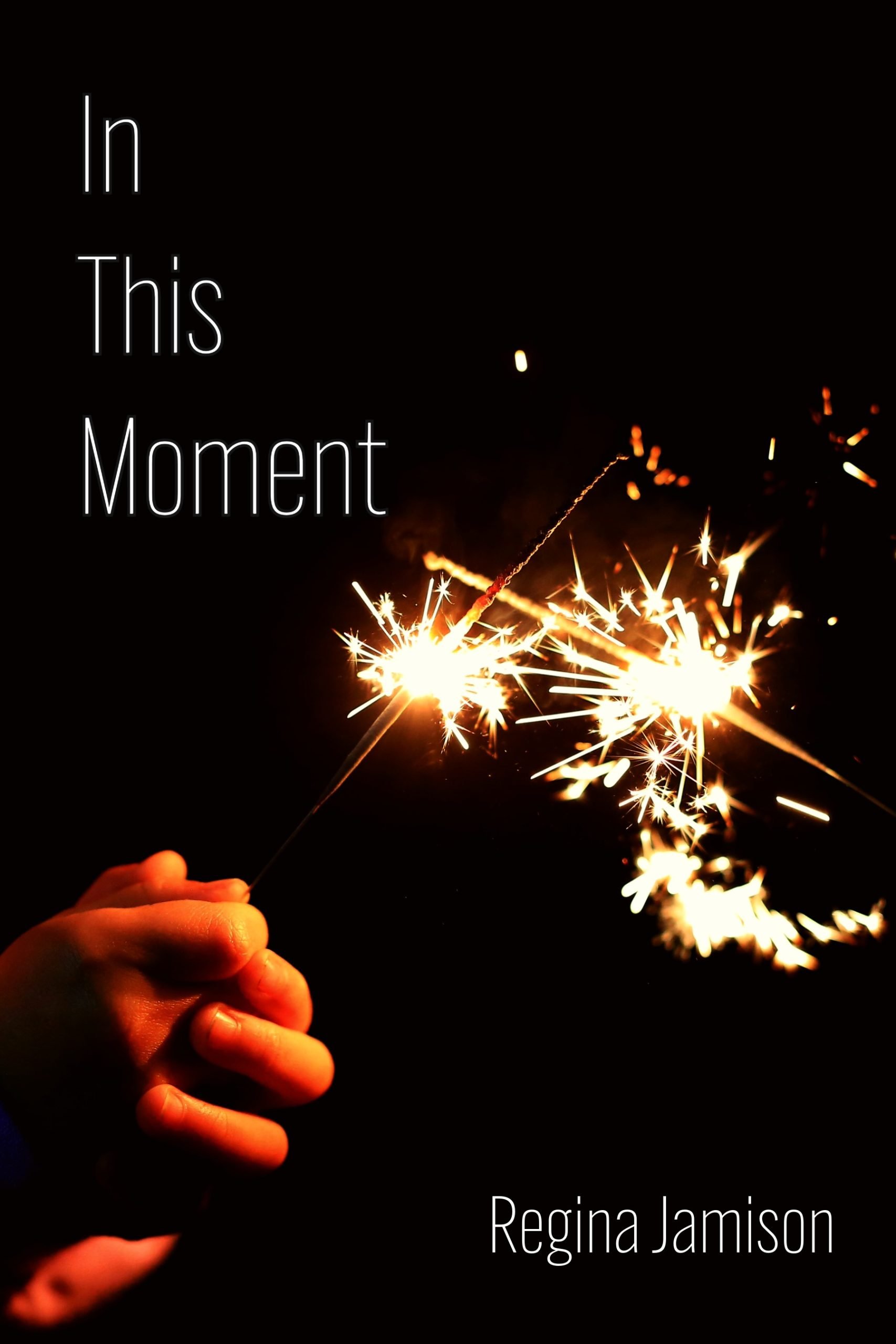 bkack background with a pair of hands holding a sparkler
