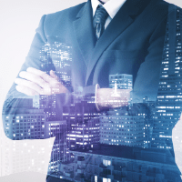 مدير تنفيذي واثق يقف وذراعاه متقاطعتان مع تداخل بصري لأفق مدينة حديثة، يرمز إلى القيادة، والاستراتيجية، والرؤية المؤسسية.