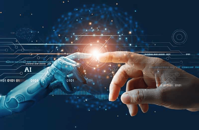 يد بشرية ويد روبوتية تلتقيان عند نقطة ضوئية رقمية، ترمز إلى التكامل بين الإنسان والذكاء الاصطناعي والتقنيات المتقدمة.