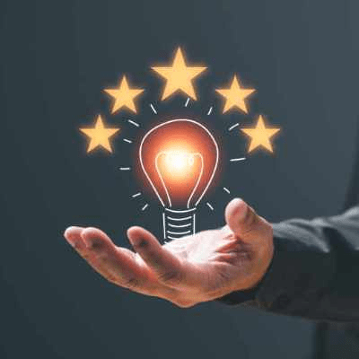 مصباح مضيء يطفو فوق كف يد مفتوحة تحيط به خمس نجوم، يرمز إلى الابتكار، الإبداع، والتميّز في الأداء.