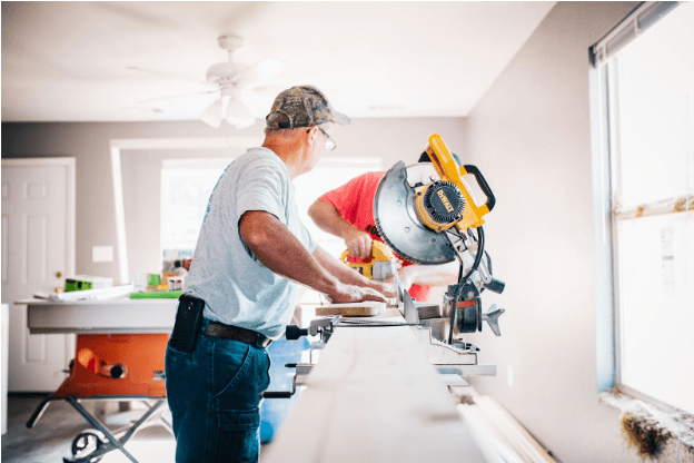 Contractors cutting wood during a home remodel, showing the renovation process supported by an FHA 203k loan.