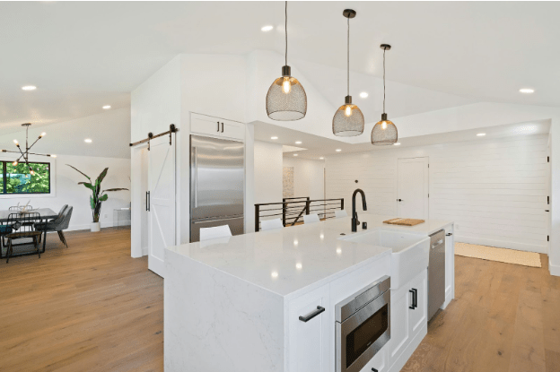 Newly renovated modern kitchen with white island and wood flooring, the type of transformation possible through an FHA 203k loan.