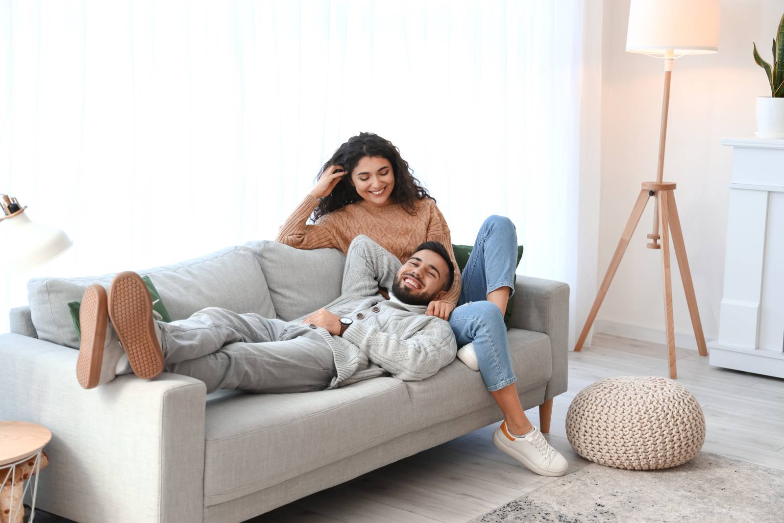 A couple in cozy sweaters holding each other at home, calm and reassured