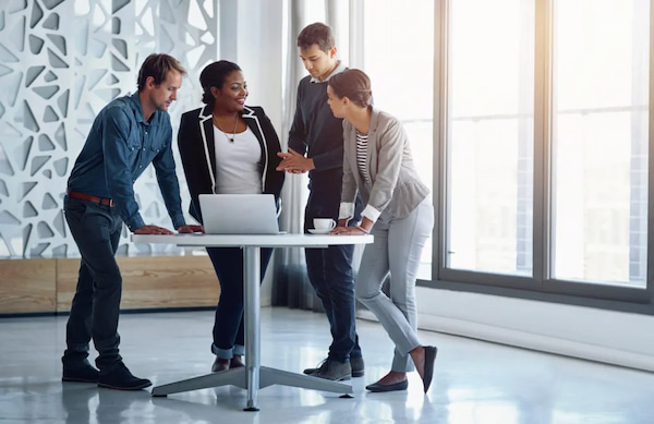 A group of employees two male and two female in the office together on a meeting to discuss business strategy.