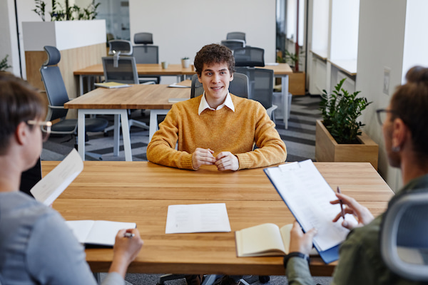 A-picture-of-a-recent-grad-in-his-first-job-interview-in-front-of-two-hiring-managers