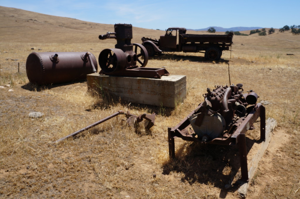 Domingas Mine compressor with tank powered by a 4 cylinder gas engine. Ore truck in background.