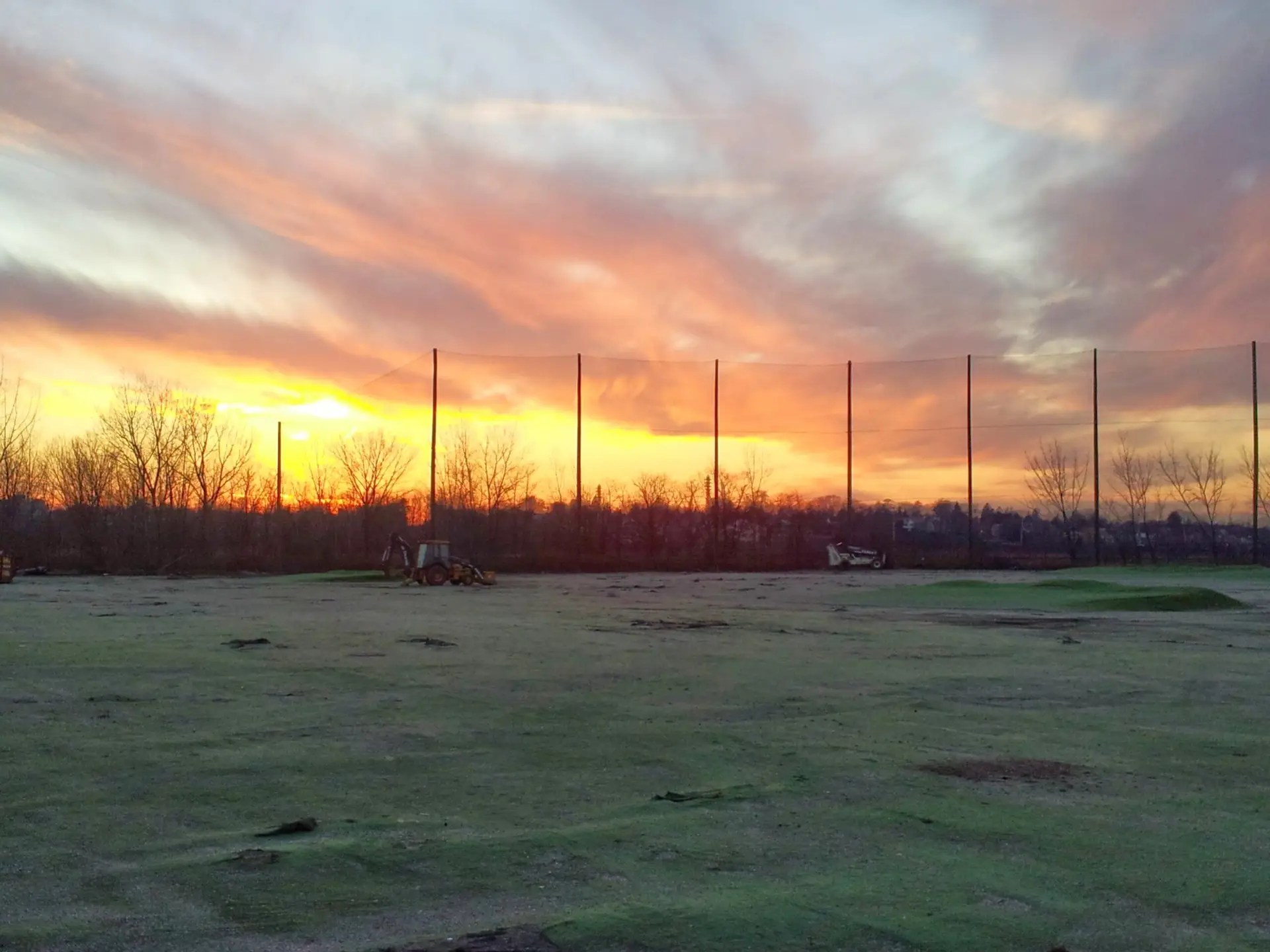 Driving range barrier netting with wood support poles