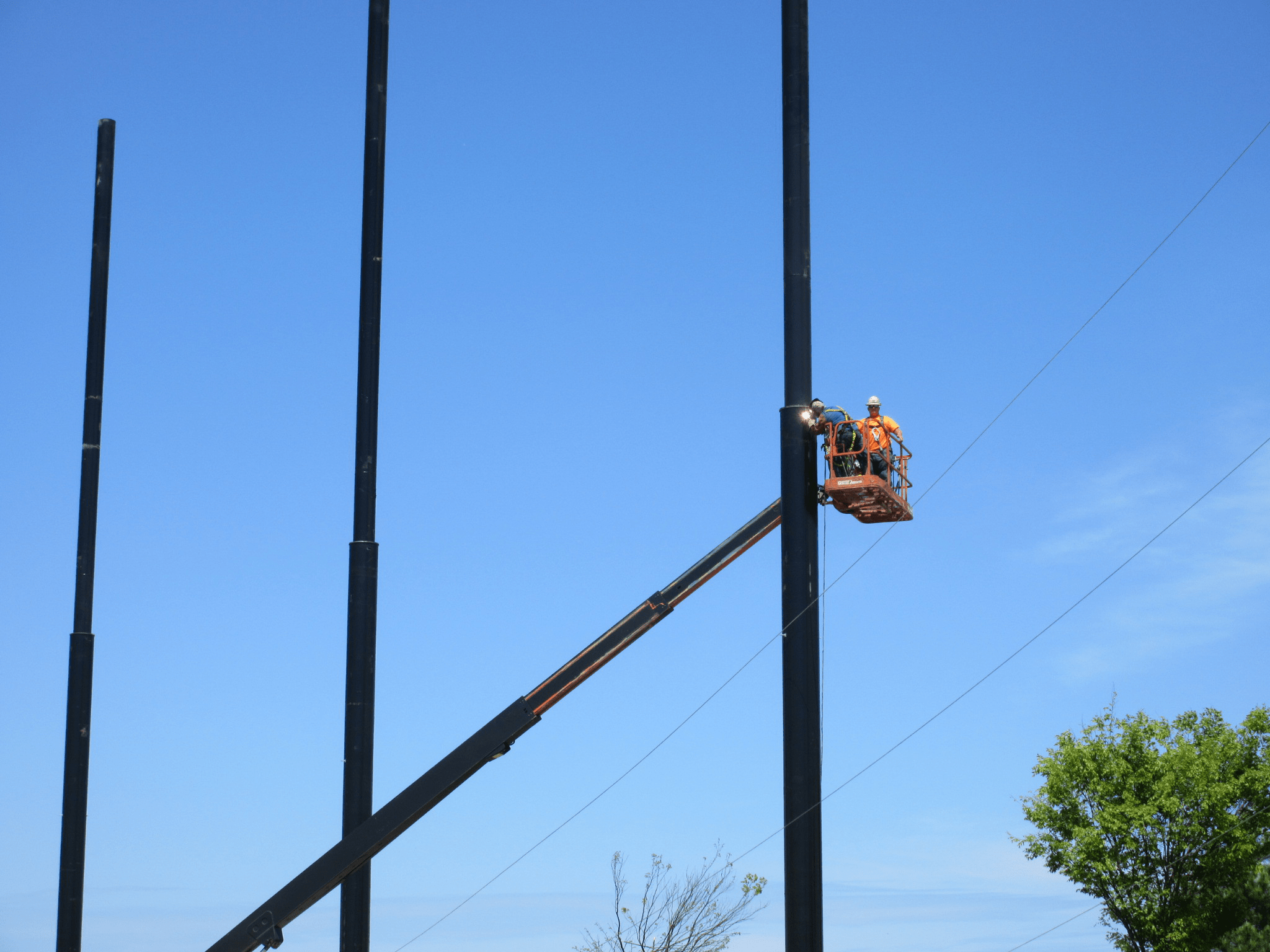 Installation crew installing cabling to support the golf netting
