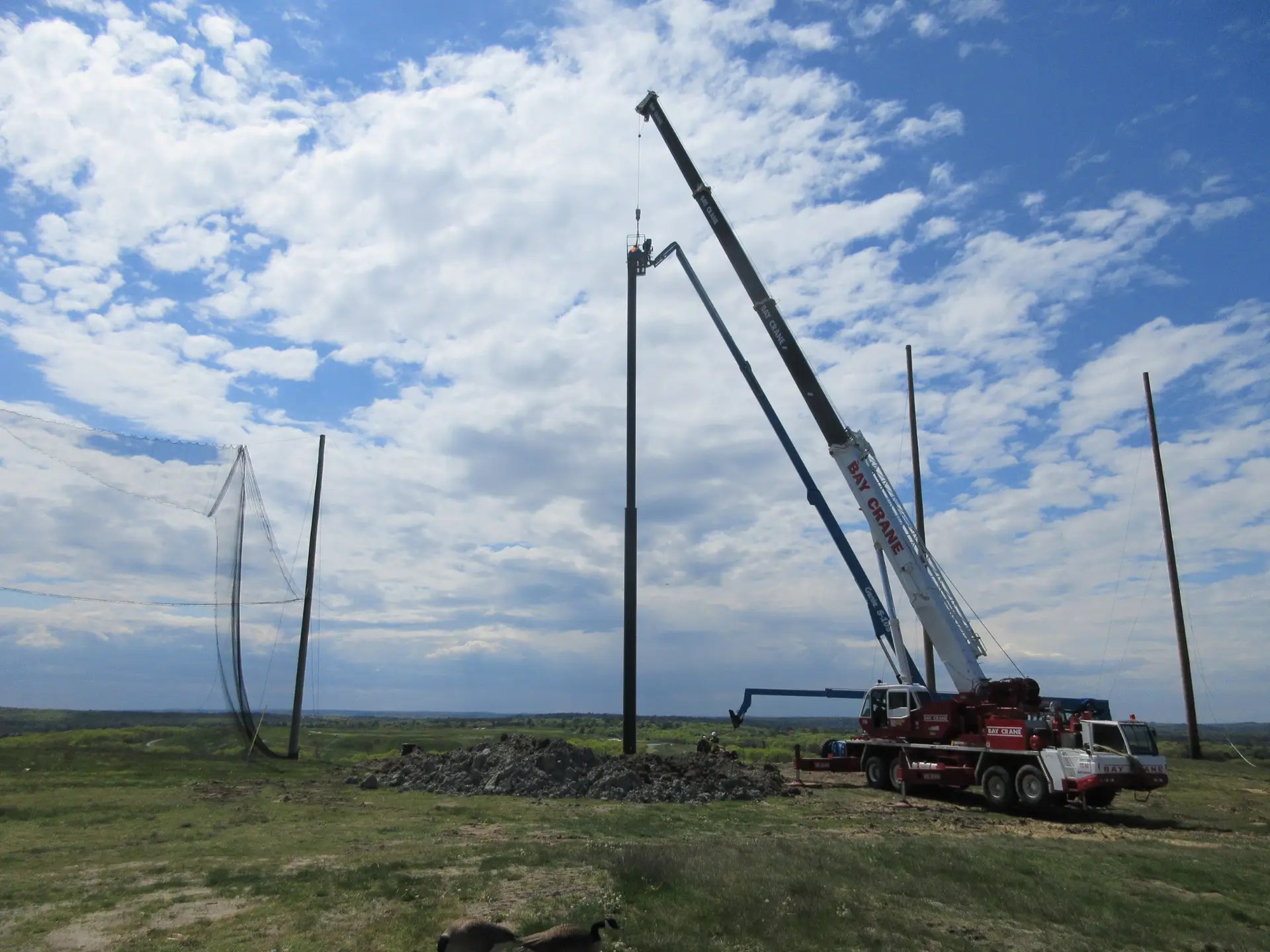 Steel support pole installation for driving range