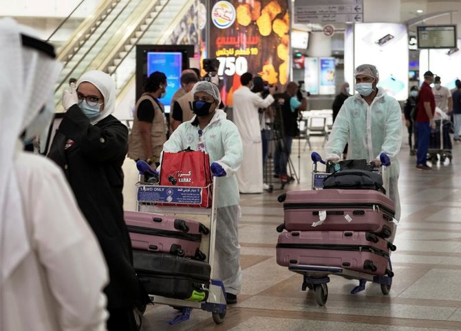 Orang Kuwait yang direpatriasi dari Amman, mengenakan masker dan pakaian pelindung wajah, terlihat setelah tiba di Bandara Kuwait, menyusul wabah penyakit coronavirus (COVID-19), di Kuwait City, Kuwait 21 April 2020. (Reuters)